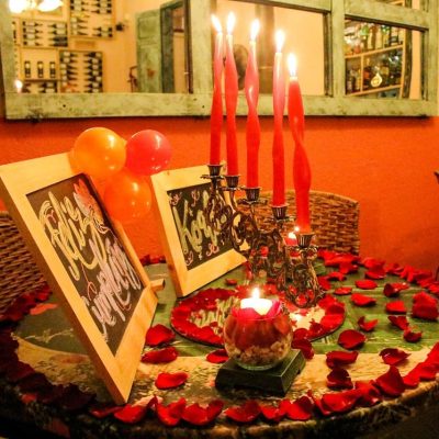 Mesa Romántica con Velas, Pétalos de Rosa y Dos Letreros Vintage Decorativos